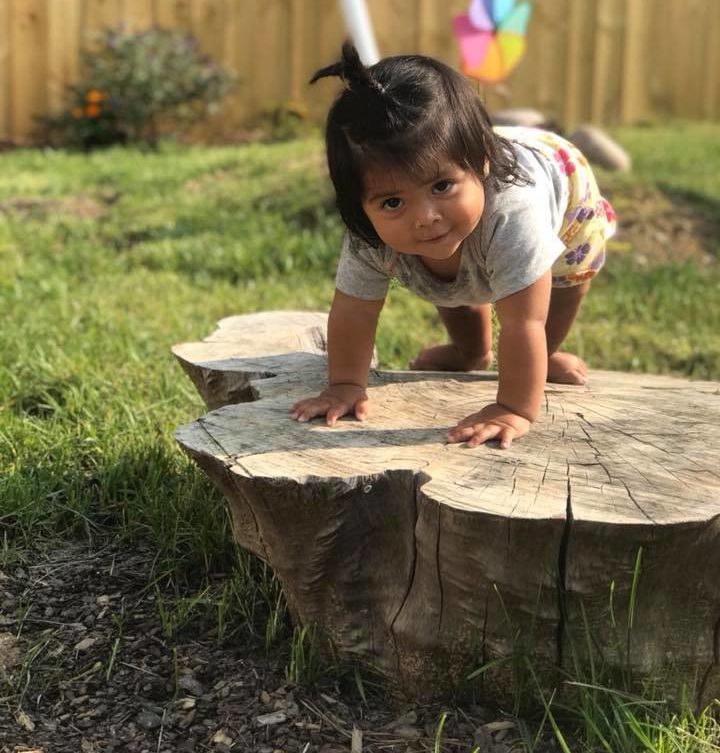 girl climbing on a stump