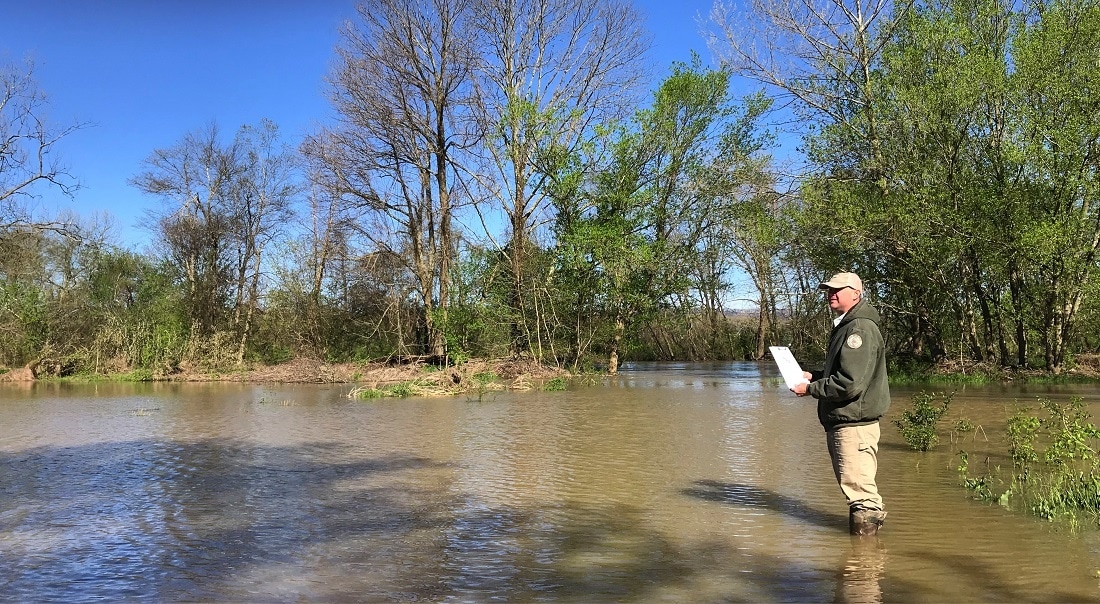 Scott Loftis wades into floodwaters at the Mouth of Mud Creek.